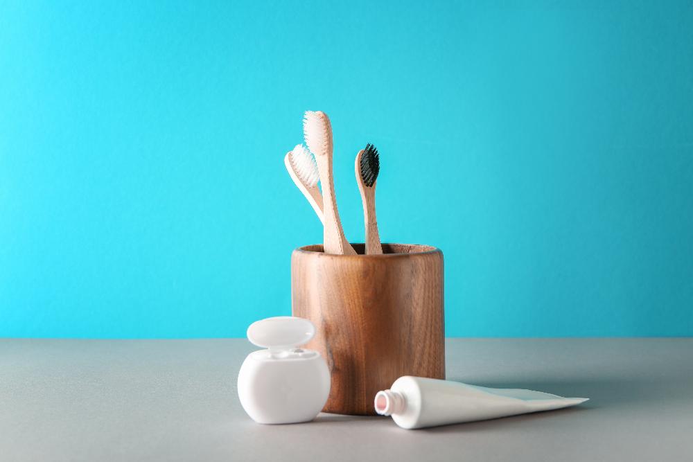 Floss and toothpaste next to a wooden toothbrush holder, los gatos ca