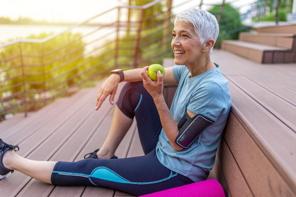 older woman eating apple | dental implants los gatos ca