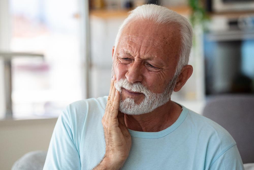 older man holding jaw in pain | bruxism treatment los gatos ca