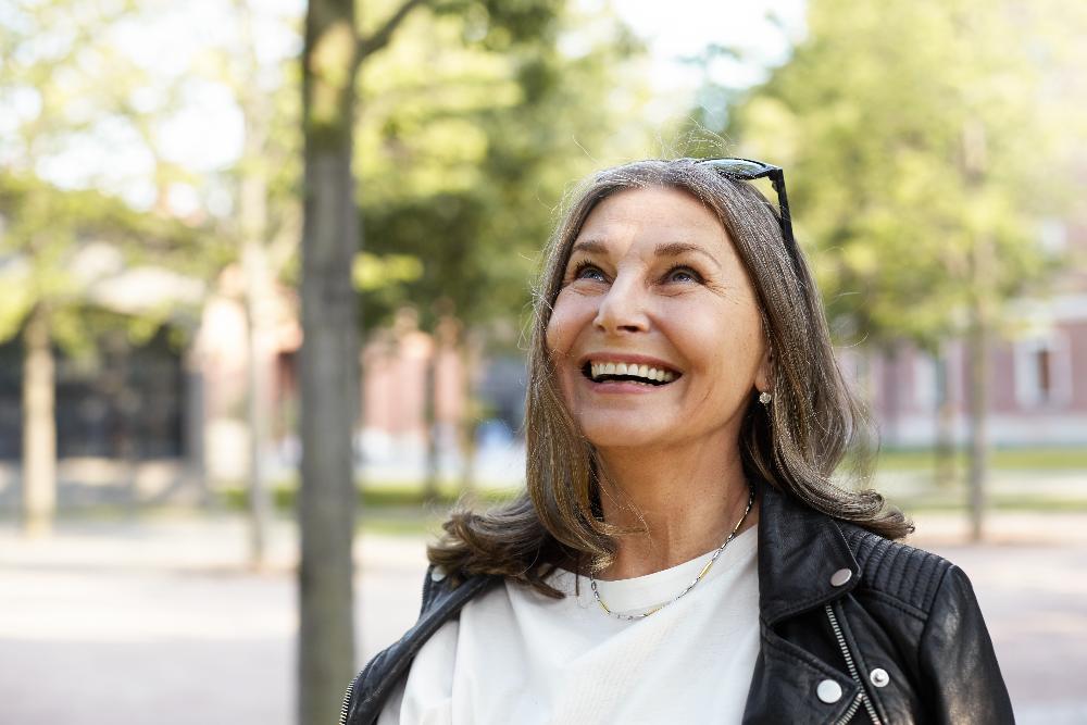 older woman in park smiling | los gatos dental implants
