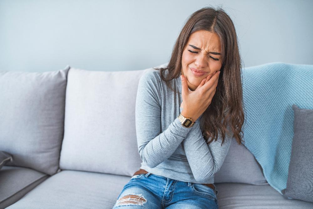 woman in pain on couch | tmj los gatos ca