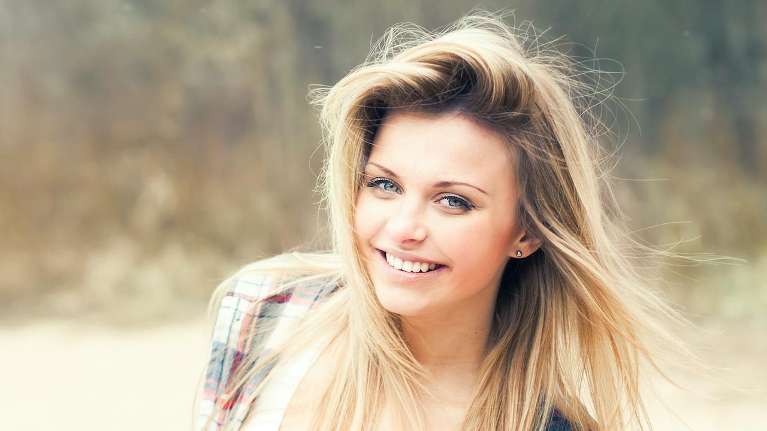 woman with blonde hair smiling | dentist near me