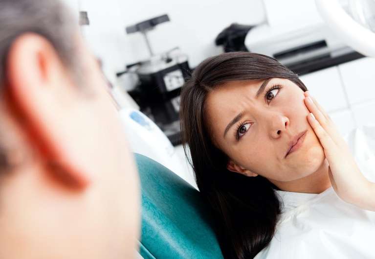 woman holding jaw with dentist | tmj solutions los gatos ca