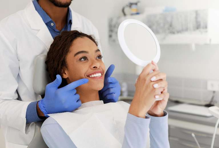 woman smiling with mirror | teeth whitening los gatos ca