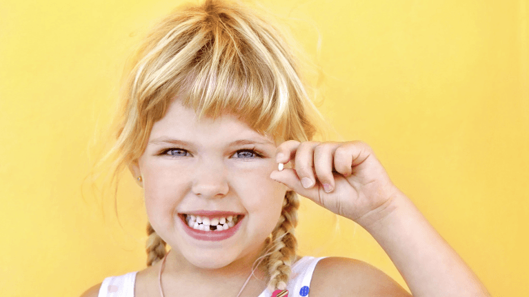 little girl holding lost tooth | children's dentist los gatos ca